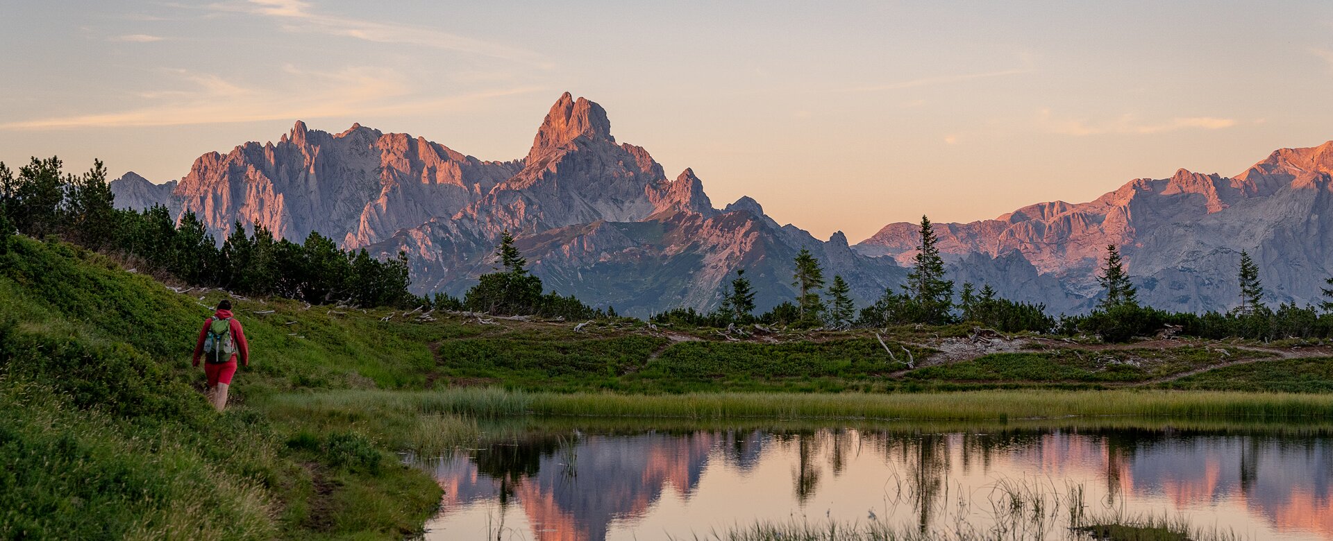 Wanderer am Gerzkopf bei Eben im Pongau vor Teich mit Blick auf Dachstein im Abendlicht | © TVB Eben - Nina Kraxner