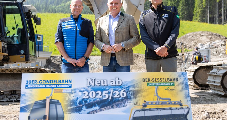 Drei Männer stehen vor Baggern und einem Schild für neue Lifte ab der Saison 2025/26. | © Harald Steiner