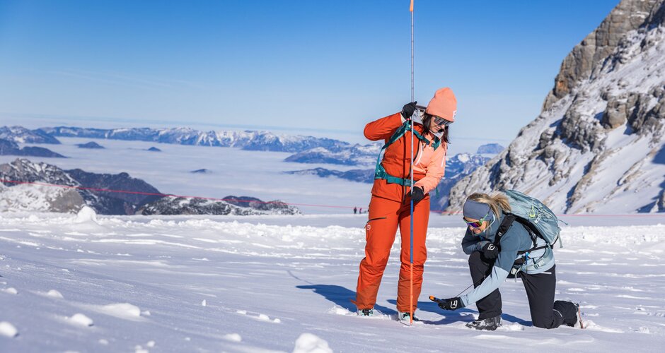 Zwei Frauen üben mit Sonde und LVS-Gerät die Verschüttetensuche im Schnee am Gletscher. | © René Eduard Perhab
