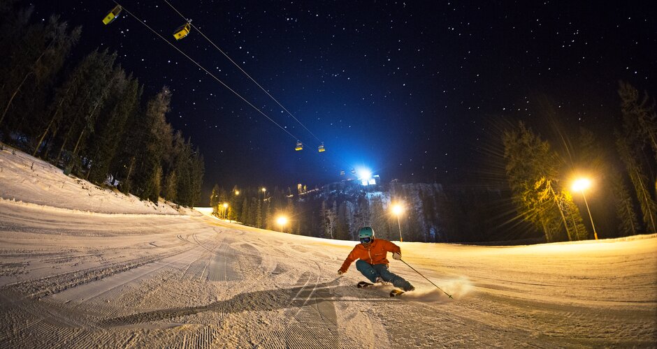 Skifahrer bei Nacht auf frisch präparierter Piste in Hochwurzen unter Sternenhimmel | © Gregor Hartl
