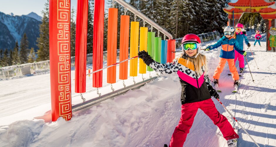 Skifahrende Kinder im Hopsi-Winterkinderland Planai mit buntem Spielparcours im Schnee | © Christine Höflehner