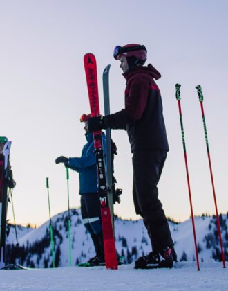 Four skiers stand on a snowy slope under a violet sky. | © Ski amadé