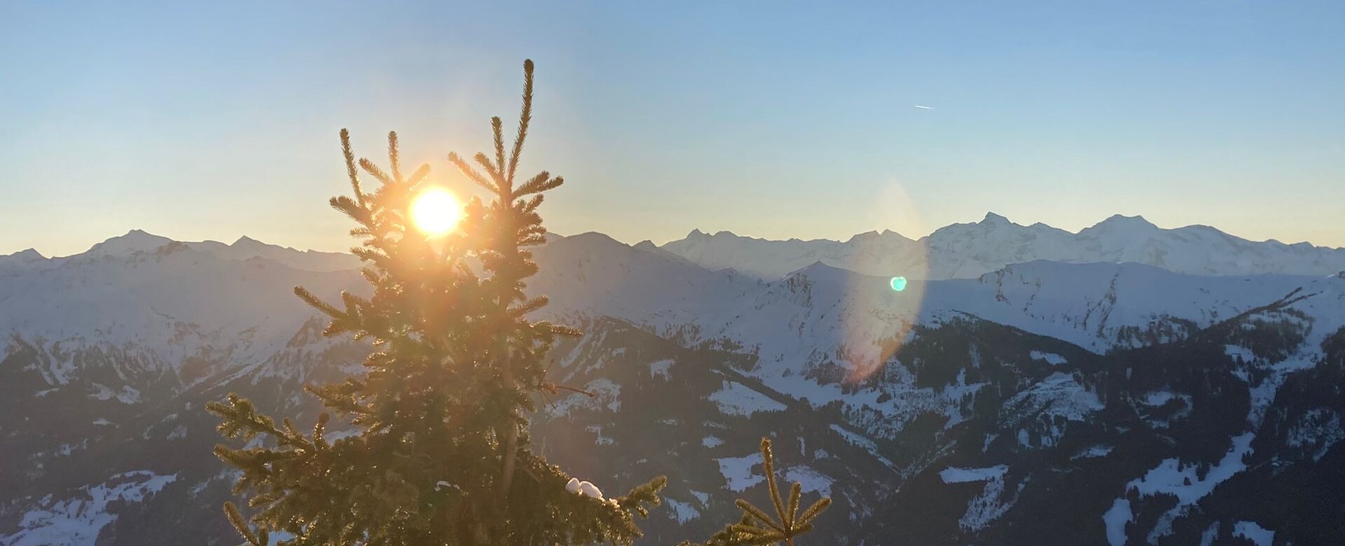Sonnenuntergang hinter Tannenspitze mit verschneiten Bergen und Tal bei Dorfgastein