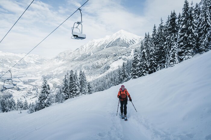 Ski tour on Graukogel with view into Gastein valley | © Gasteinertal Tourismus GmbH, Christoph Oberschneider Female ski tourer climbs Graukogel under lift with scenic valley view and snow-covered trees | © Gasteinertal Tourismus GmbH, Christoph Oberschneider
