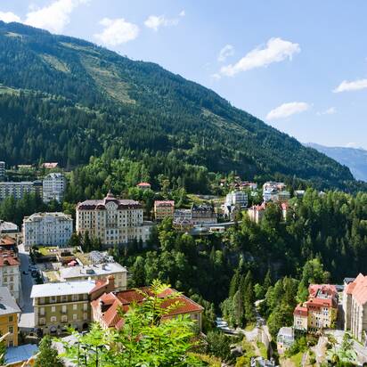Panoramic view of Bad Gastein with historic hotels, church and green mountains in summer | © Georg Roske