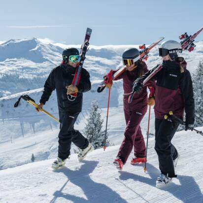 Drei Skifahrer mit Ausrüstung gehen über verschneite Piste auf der Schlossalm in Gastein | © Gasteinertal Tourismus GmbH, Christoph Oberschneider