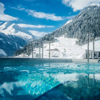 Swimming pool with mountainous snowy landscape in the background | © Max Steinbauer Photography