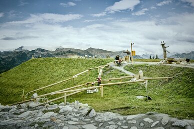 Children play at water stations on adventure trail in Grossarltal with wooden channels meadow and mountains | © Chris Rogl