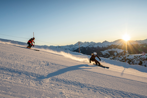 Zwei Skifahrer beim Carven auf frisch präparierter Piste im Großarltal bei Sonnenaufgang | © TVB Grossarltal / Lorenz Masser