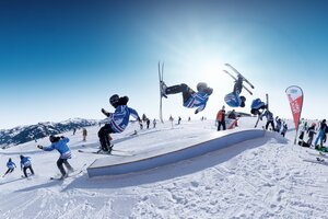 Ein Freeskier zeigt bei Cash4Tricks im RIDE Ski amadé einen Frontflip über ein Rail, festgehalten als Serienaufnahme.