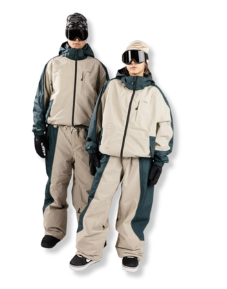 Zwei Personen tragen ein beige-türkisfarbenes Snowboard-Outfit von Blue Tomato 1080 mit Jacke, Hose, Handschuhen und Skibrillen.